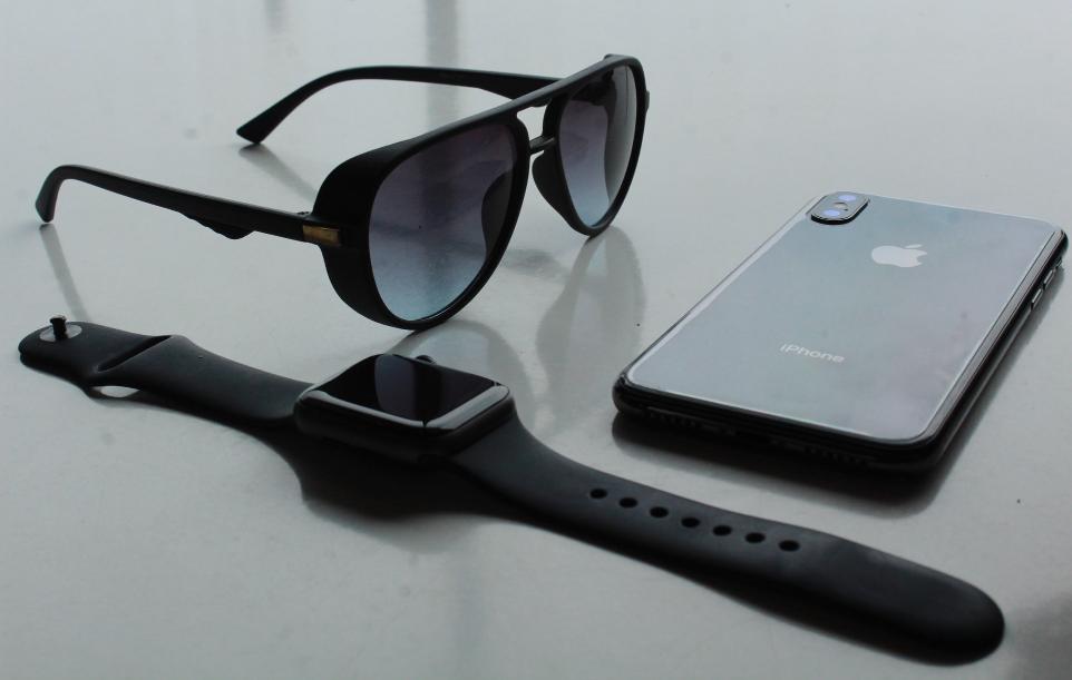 black sunglasses beside space gray iPhone X